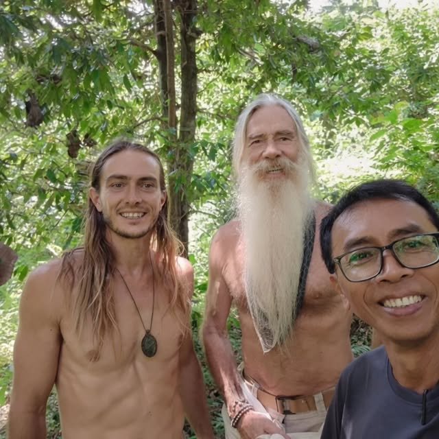 Keith with two men, standing under the trees