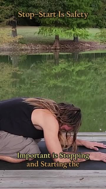 Keith folded forward on a mat beside the water
